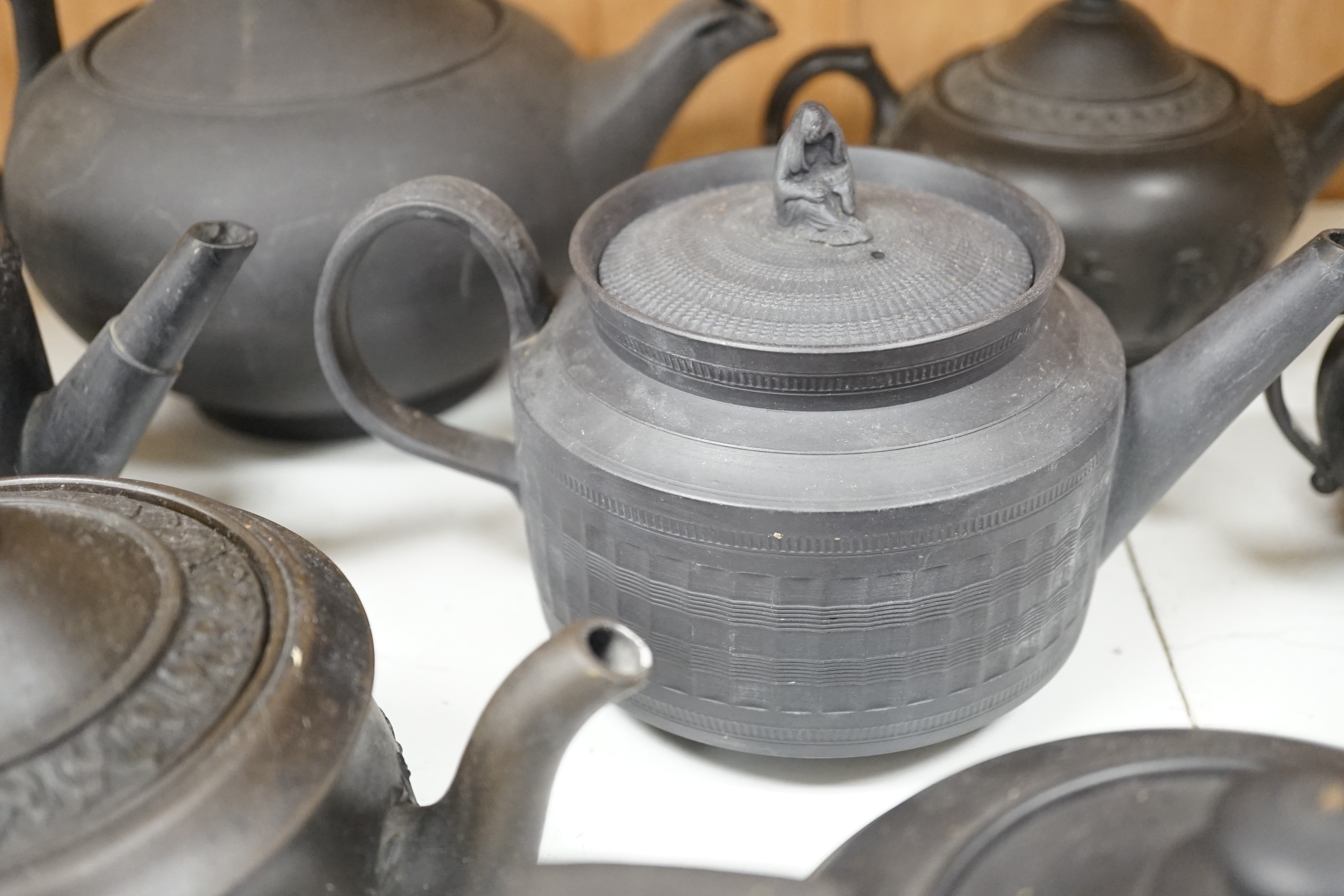 A collection of Wedgwood and other black basalt teapots and tea wares, 19th/early 20th century, tallest teapot 17cms high